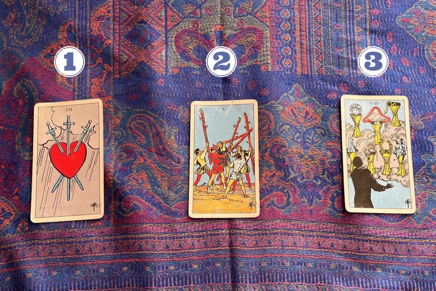 3 cartas del Tarot reveladas sobre una tela.