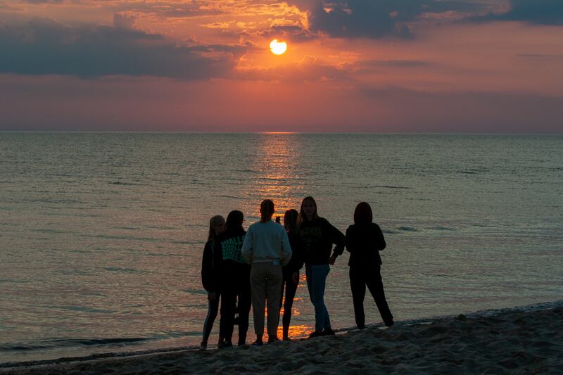 Amigos viendo la puesta de sol en la playa.