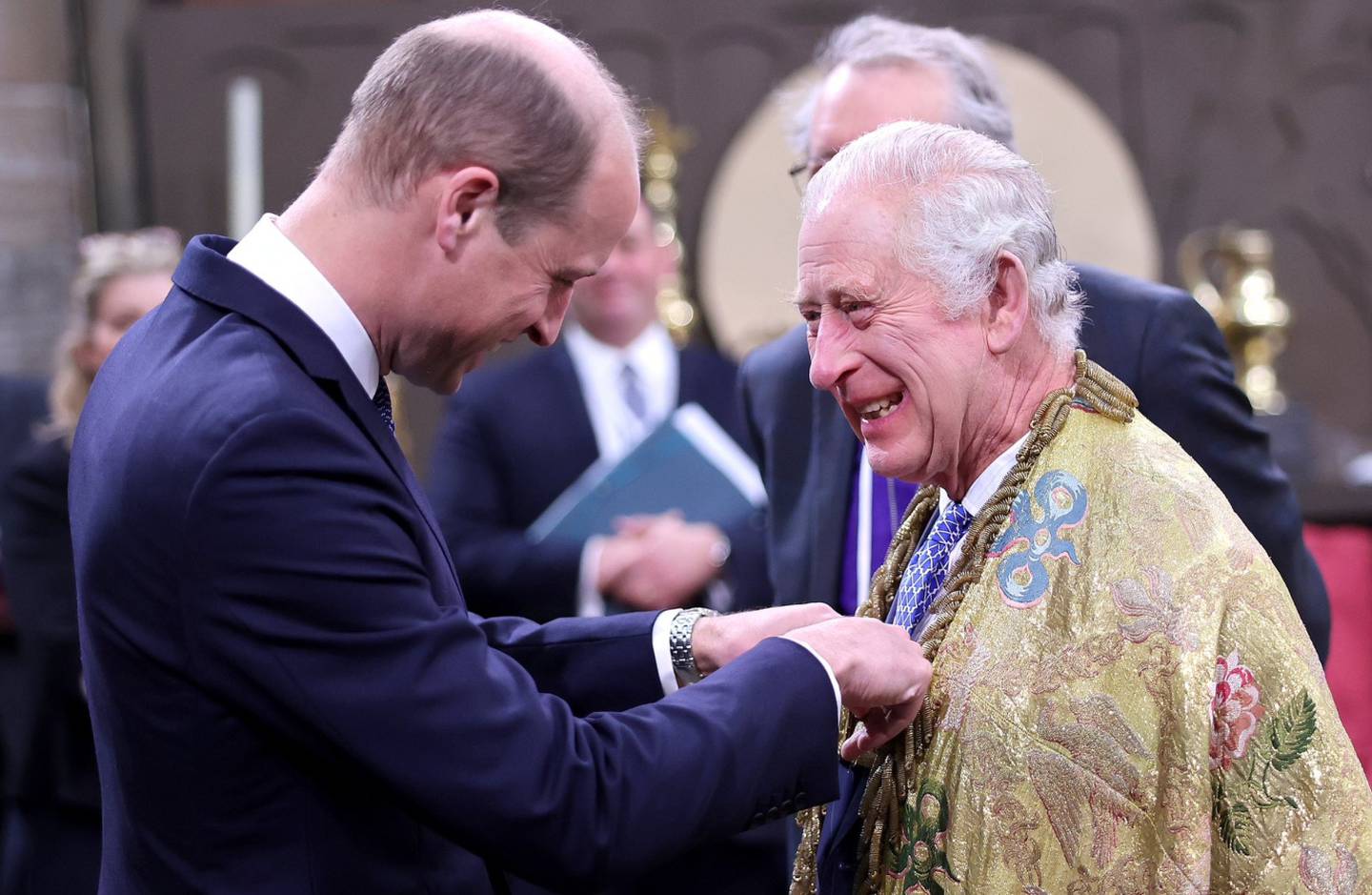 El príncipe William ayudando a su padre, el rey Carlos en el día de la coronación.