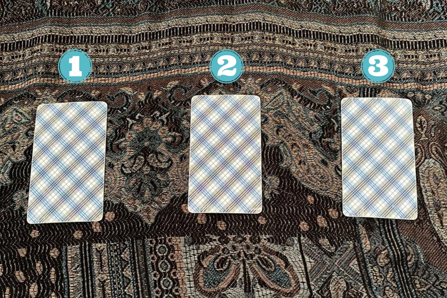 tres cartas del tarot encima de una tela.