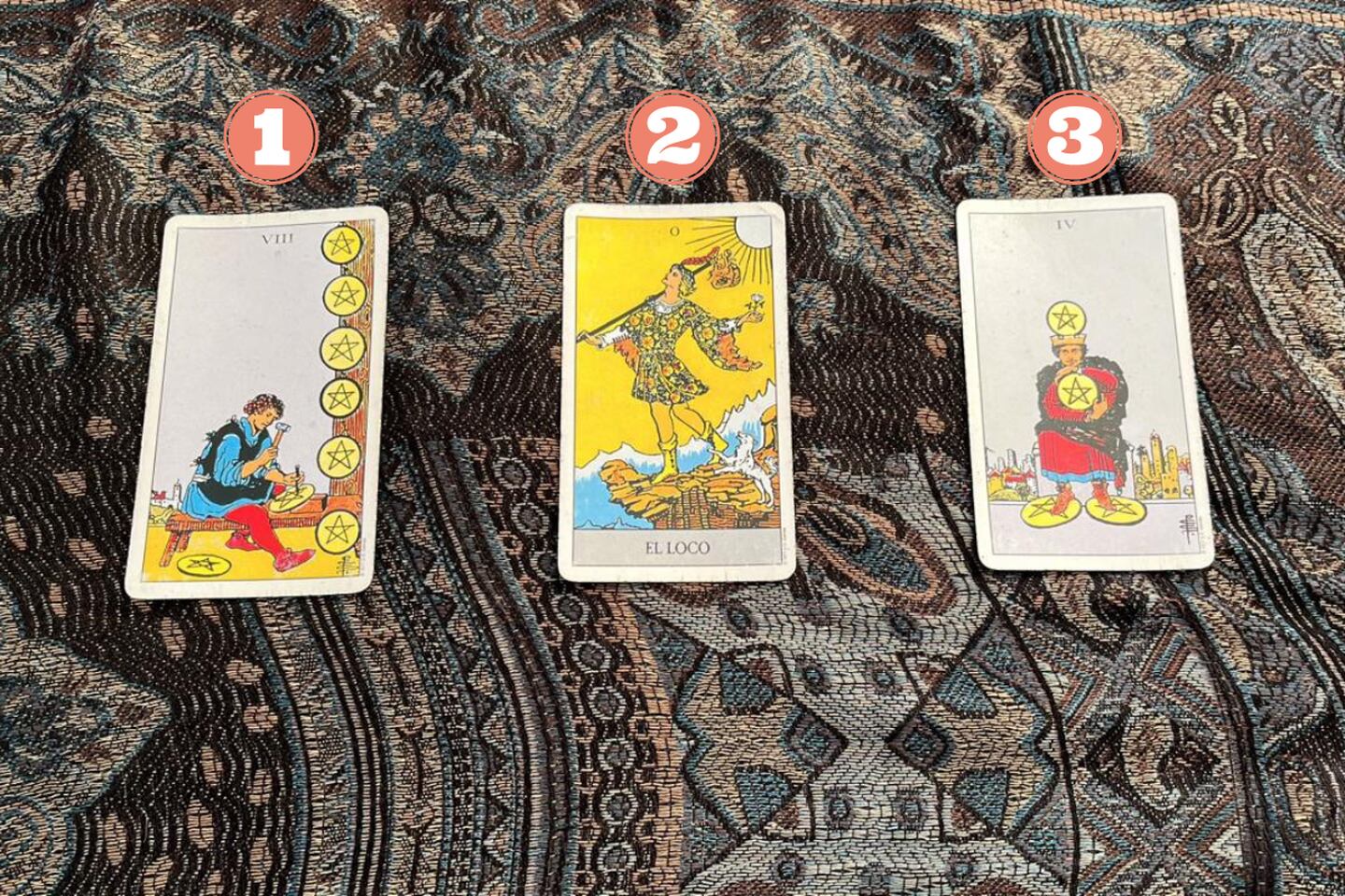 Tres cartas del Tarot reveladas sobre una tela.