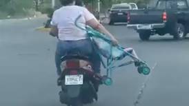 VIDEO | Mujer en motoneta fue captada mientras llevaba a su hija colgando de una carriola