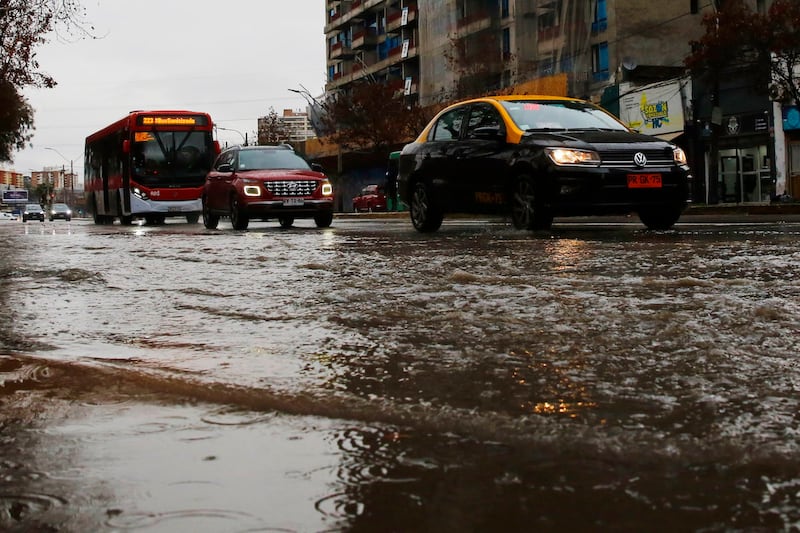 Vehículos transitando bajo la lluvia en Santiago.