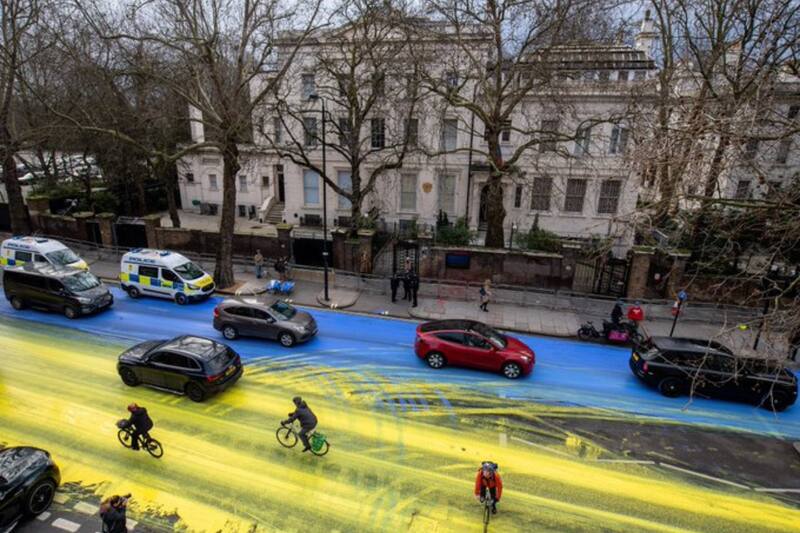 Activistas pintan la bandera de Ucrania frente a la embajada Rusa en Londres. Créditos:Twitter @ByDonkeys