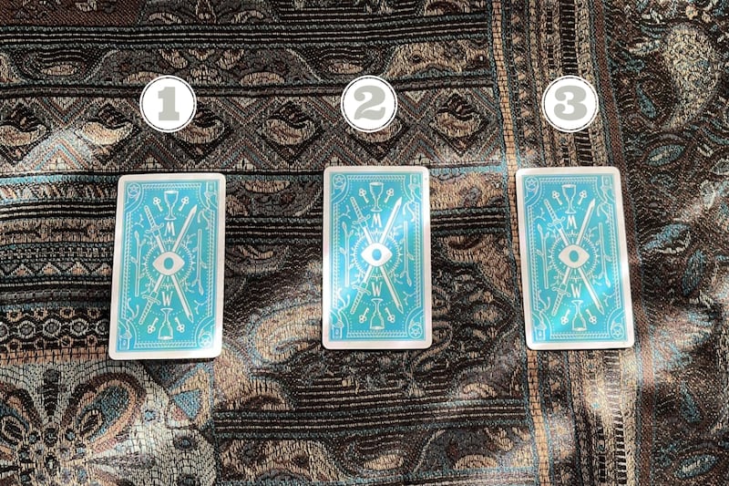 tres cartas del tarot sobre una tela.