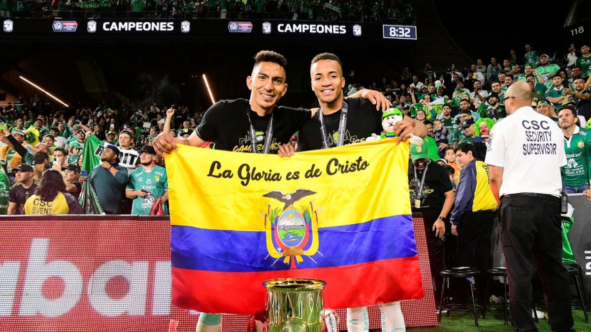 Los futbolistas ecuatorianos Ángel Mena y Byron Castillo sosteniendo la bandera de Ecuador tras ganar la Liga de Campeones de Concacaf con el Club León.