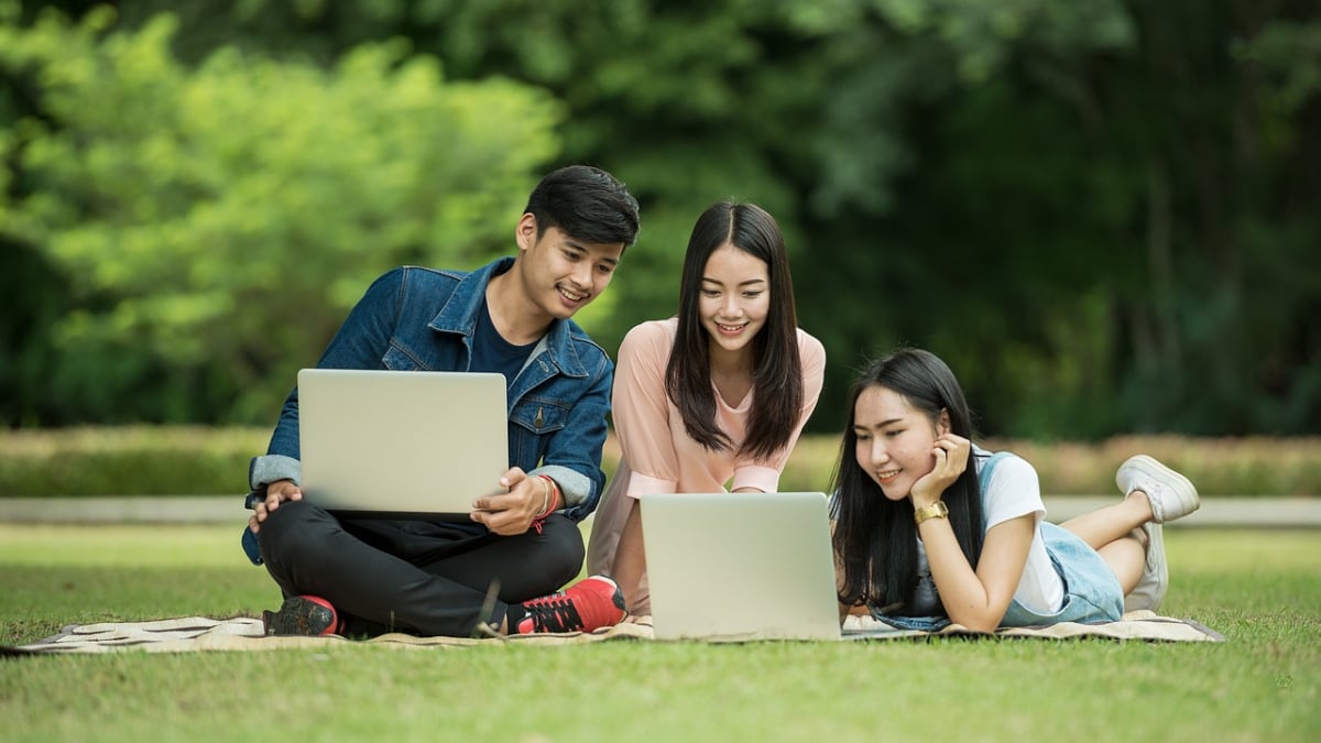 Jovenes estudiante en un parque con computadoras